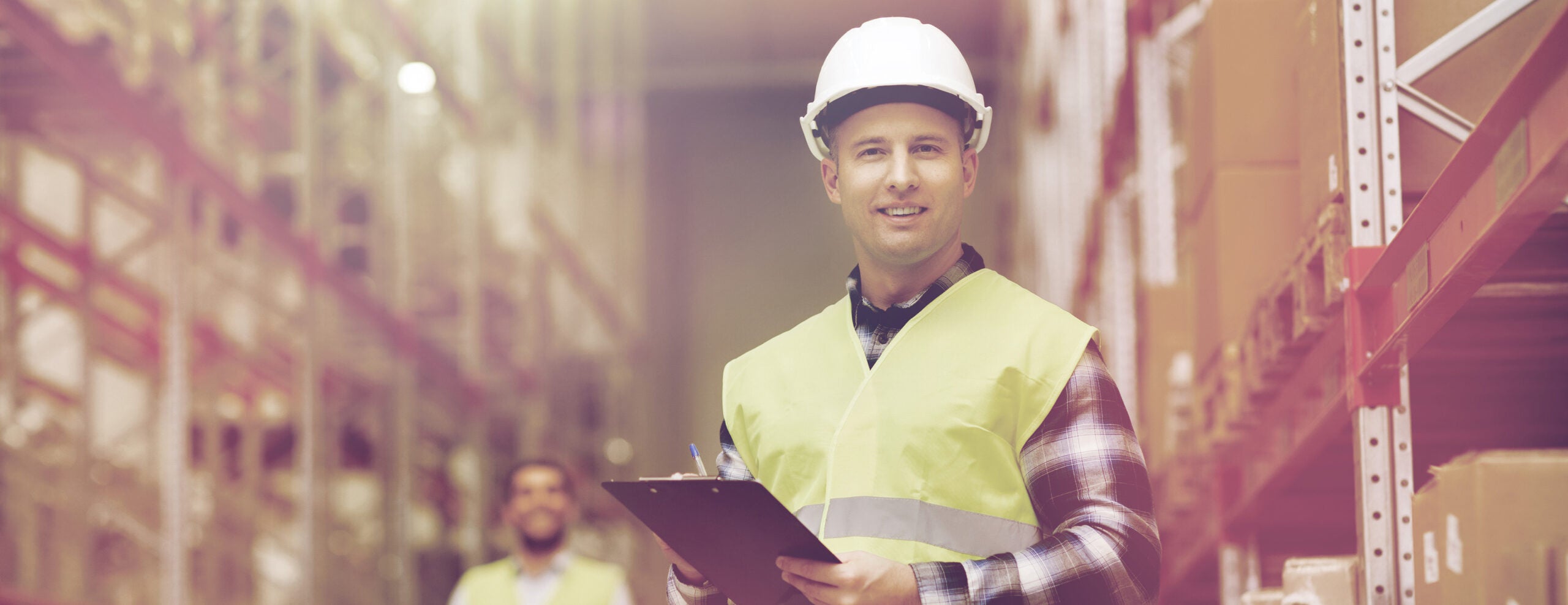 Warehouse employee wearing a hard hat and high-visibility vest